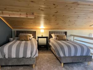 MarathonFroggy Goggle Barn的卧室设有两张床铺和木制天花板