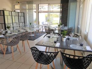 圣维克托Hotel Restaurant Le Jardin Délice的一间在房间内配有桌椅的餐厅
