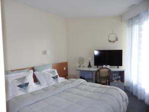 圣维克托Hotel Restaurant Le Jardin Délice的卧室配有一张白色大床和电视。
