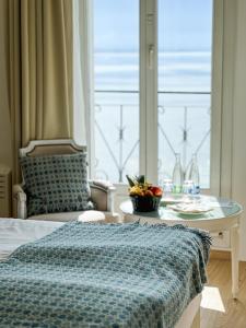 蒙特勒伊甸园宫奥拉克酒店的一间卧室配有一张床、一张桌子和一个窗户。