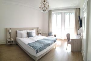 蒙特勒伊甸园宫奥拉克酒店的白色卧室配有一张床和一个吊灯