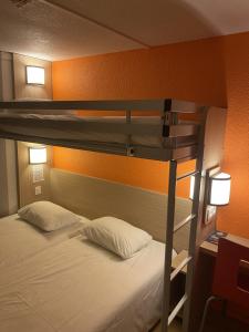拉库罗讷普瑞米尔昂古勒姆拉库洛那经典酒店的卧室配有带白色枕头的双层床