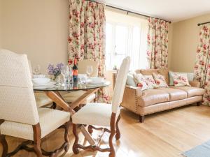 鲁吉利Bluebell Cottage的客厅配有桌子和沙发