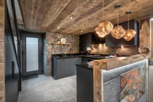 LindaleCoronation Cottages, Modernised 200-Year-Old Lake District Cottage Getaway for Two的厨房配有黑色橱柜和木制天花板