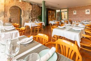 Villavieja del LozoyaHospedería el arco的餐厅设有白色的桌子和木椅