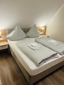 旺格兰Hotel Seewiefken的一张白色的大床,带两条毛巾