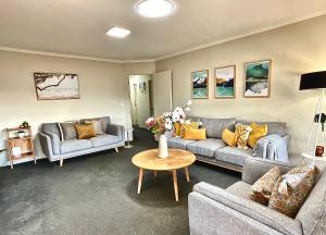 陶朗加Free-Range On Papmoa Beach的客厅配有两张沙发和一张桌子