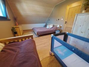 贝谢诺瓦CHALUPY TRI GROŠE VLAŠKY的一间设有一间卧室、一张床和一张婴儿床的房间