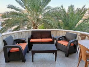 杰里科BnB La Luna Entire Apartment的一个带桌椅的阳台和棕榈树