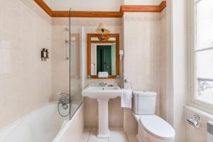 里昂全球塞西尔酒店的浴室配有盥洗盆、卫生间和浴缸。