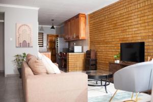 帕拉佩The Cosy Crib的带沙发和砖墙的客厅