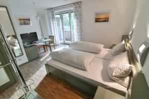 文西德尔Luisenburg Resort的客房设有一张床、一张书桌和电视