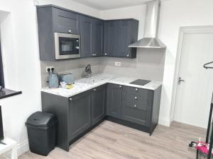 Batley CarrHomestay by BIC Legends 4的厨房配有黑色橱柜和水槽