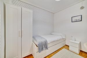 洛格罗尼奥Las terrazas de Castañares by Clabao的一间白色的小卧室,配有一张床和一个衣柜