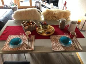 翁根Hop in Nest Cozy B&B in Wengen的一张桌子,上面有两盘盘子和一盘食物