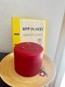 翁根Hop in Nest Cozy B&B in Wengen的木板上的红色蛋糕,上面有标志