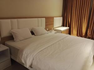 名古屋Free Shuttle Thamrin City Apartments at Nagoya with Netflix & Youtube Premium by MESA的一间卧室配有一张带白色床单的大床