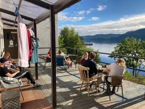 因弗莫里斯顿Loch Ness Lochside Hostel, Over 16s Only的一群人坐在甲板上,享有水景