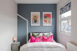伦敦Stunning 3 Bed Duplex Apartment in the heart of West Hampstead的卧室配有粉色和绿色枕头。