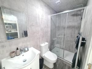 Batley CarrHomestay by BIC Legends 5的带淋浴、卫生间和盥洗盆的浴室