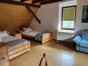 KnittelsheimLandhotel Garni Knittelsheimer Mühle的客房设有两张床、一张沙发和一个窗口。