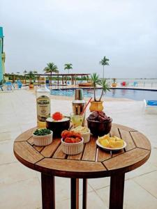 阿拉亚尔-杜卡布Golden Lake Arraial do Cabo Resort的餐桌旁的桌边,桌边有食物和饮料