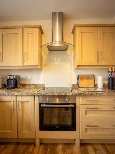马特洛克Swallow View, A Spacious Base with stunning views的厨房配有木制橱柜和炉灶烤箱。