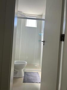 伊塔佩马Apartamento à 380m do Mar的白色的浴室设有卫生间和淋浴。