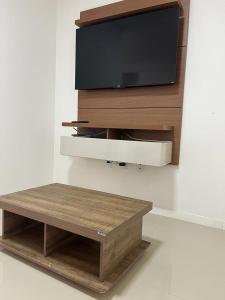 伊塔佩马Apartamento à 380m do Mar的壁挂式平面电视和咖啡桌