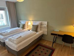 汉诺威Hami Apartments Hannover的酒店客房配有两张床、一张书桌和一张书桌。