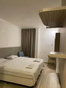SukaramiBelvena Makati Hotel的配有一张床和一张书桌的酒店客房