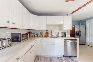 拉特兰Vermont Marble Haven - Unit 1的厨房配有白色橱柜和不锈钢冰箱