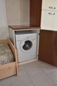 坎普码头Appartamento Amapola - Bilocale in zona mare con clima e posto auto的厨房角落里的洗衣机和烘干机
