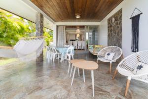 帕皮提Pamatai Chill House的庭院配有椅子、桌子和吊床。