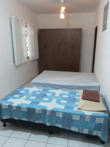 瓜拉派瑞VERDEPERTO Camping Clube的一间卧室配有一张带蓝色和白色被子的床