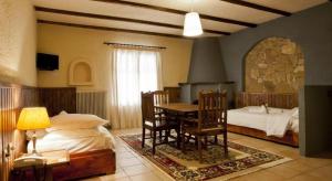 卡拉维塔Fanaras Hotel的卧室配有一张床和一张桌子及椅子