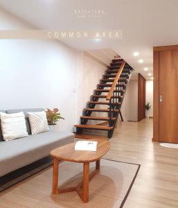 清迈NatRatcha Home Studio的带沙发和楼梯的客厅