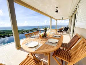 圣马丁岛Villa Grand Horizon with extraordinary 180 degree sea view的阳台的用餐室配有桌椅