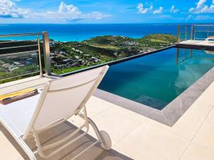 圣马丁岛Villa Grand Horizon with extraordinary 180 degree sea view的海景阳台上的椅子