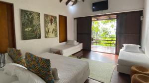 圣安德烈斯Hotel Acantilado de La Tierra的一间卧室配有一张床、一张沙发和一台电视。