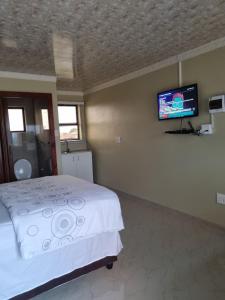 理查兹湾Airport Airbnb的一间卧室配有一张床和一台平面电视