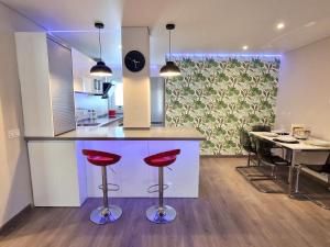 贝纳尔马德纳Emerald Apartment - Spacious Modern 2 Bedroom的厨房以及带红酒吧凳的用餐室