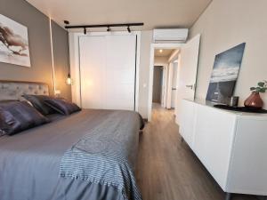 贝纳尔马德纳Emerald Apartment - Spacious Modern 2 Bedroom的一间卧室配有一张大床和白色橱柜。