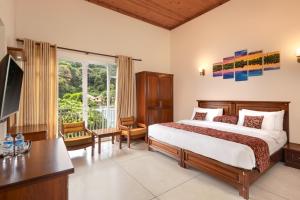 康提Hotel Cassendra的一间卧室配有一张床、一张书桌和一个窗户。