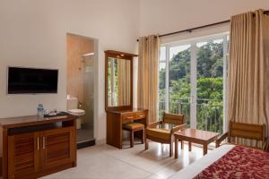 康提Hotel Cassendra的配有一张床、一张书桌和一扇窗户的酒店客房