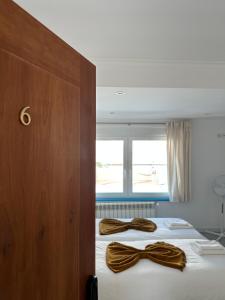 辛特拉Mega Ocean Magoito - Guest House - Sintra的两个棕色的蝴蝶结在房间里床边