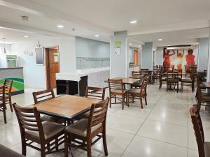 伊瓜苏伊瓜苏市CLH酒店的一间带桌椅和钢琴的餐厅