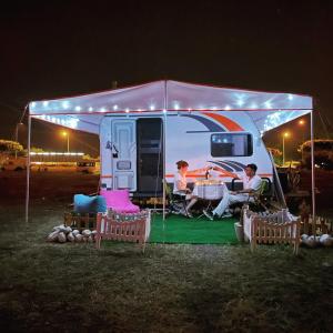 拉瑞Karavan tosbik的一群人晚上坐在野营车里