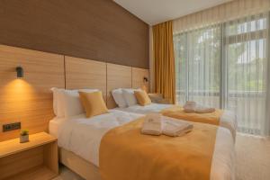 莫姆奇尔格勒Hotel Osetia Garden的酒店客房,配有两张带毛巾的床