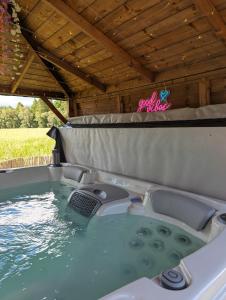德里门FINN VILLAGE "Mountain View Cottage" Private Garden, 9-seater Hot Tub, Firepit & Pizza Stove的船上的按摩浴缸,带床